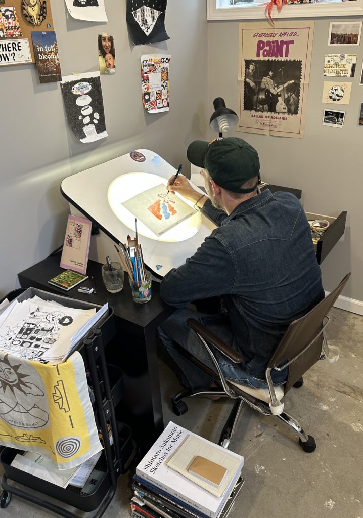 Mark Neeley painting at an animation desk